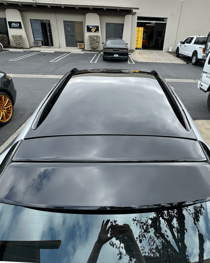 Porsche Taycan panoramic glass roof after replacement, viewed from rear showing clean seam and finish